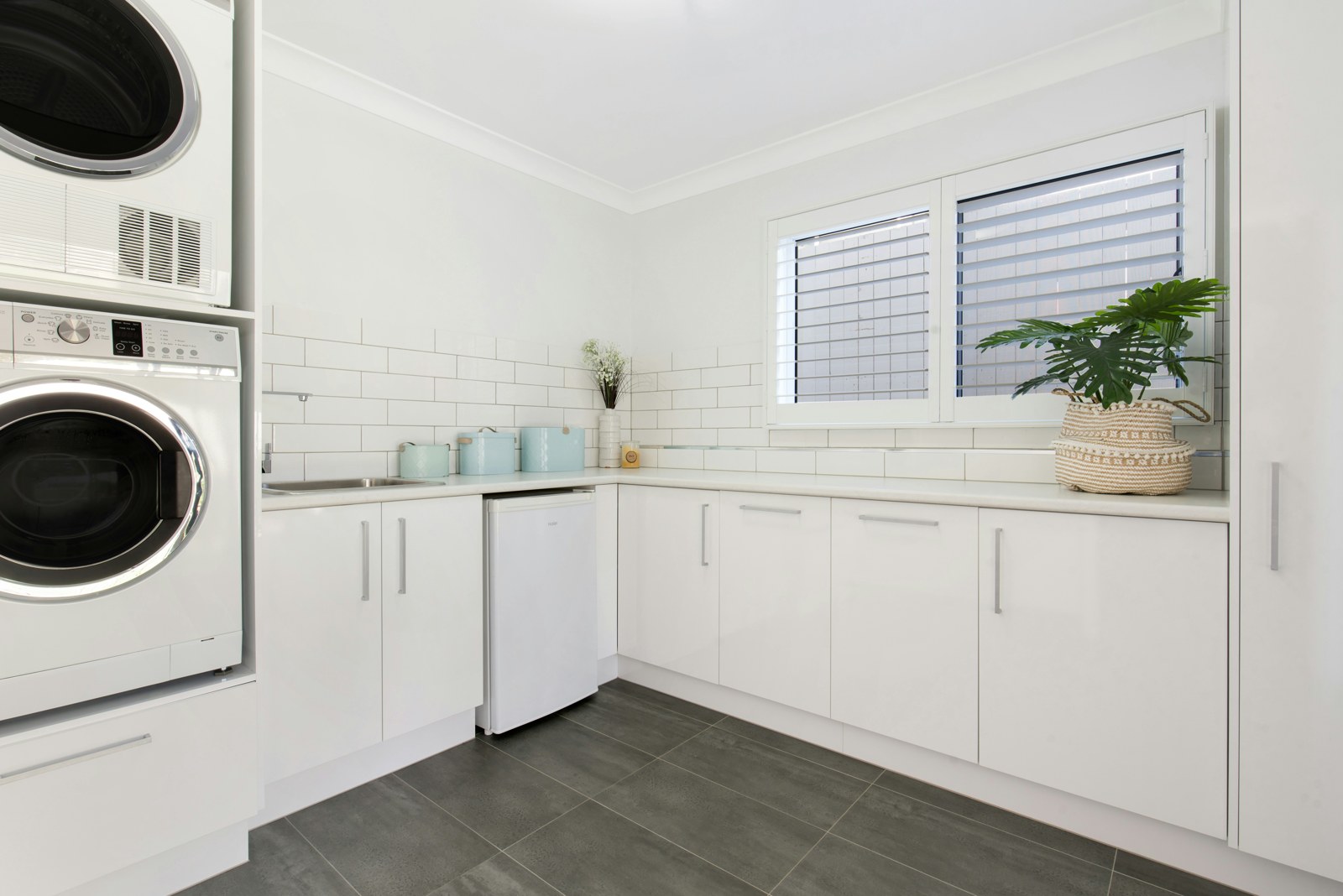 A bright residential laundry room with neatly arranged shelves